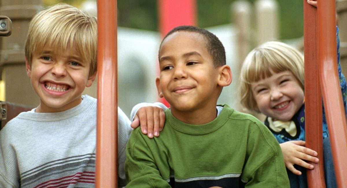 three kids playing at a playground